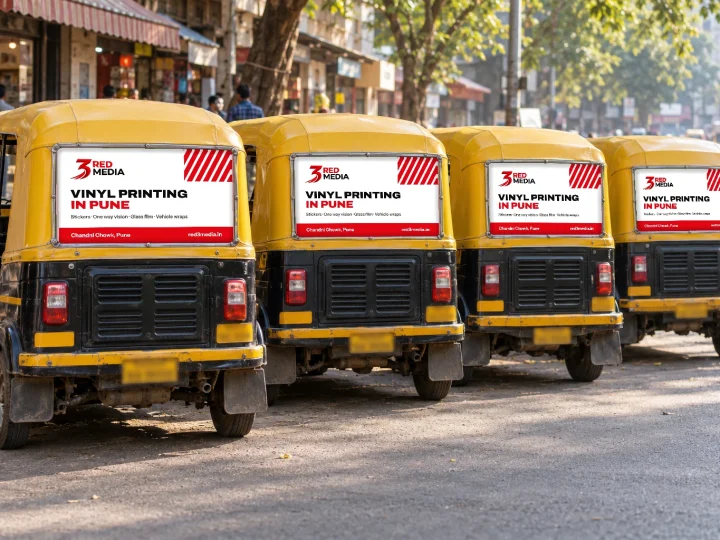 A row of Pune auto-rickshaws at an auto stand, each carrying the same printed back-panel advert