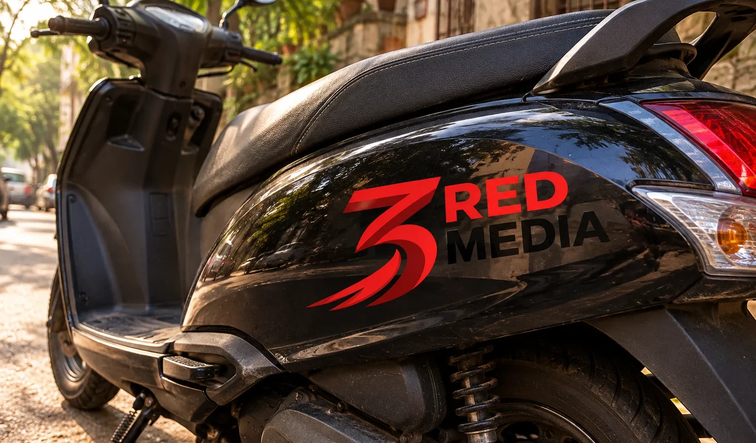 Scooter with cut vinyl graphics of the 3 Red Media logo