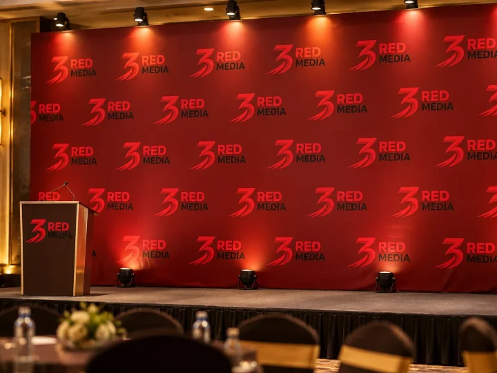 Event stage backdrop printed with a repeating 3 Red Media logo pattern