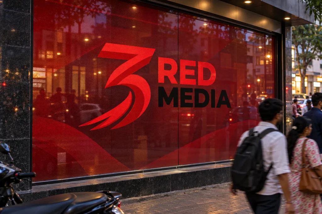Red one way vision film with the 3 Red Media logo across a street-facing window, the poster treatment a highway sales gallery could use