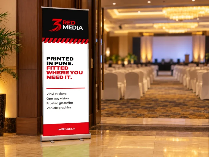 Roll-up standee at a seminar hall entrance with the 3 Red Media logo