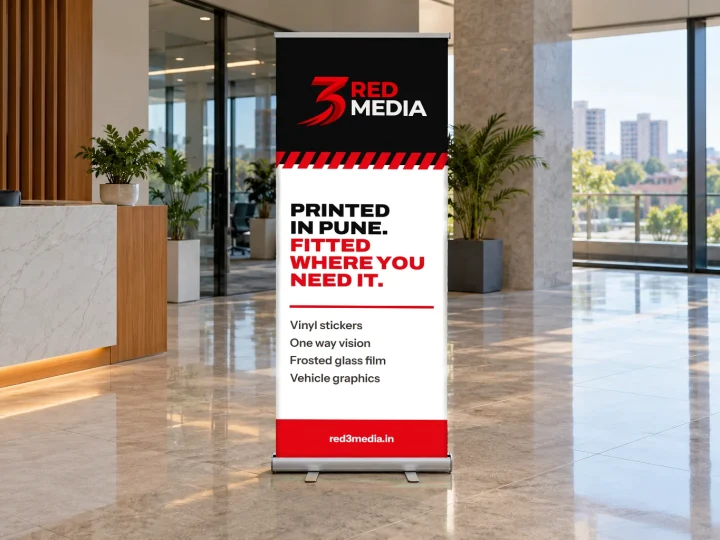 Roll-up standee printed with the 3 Red Media logo in an office lobby